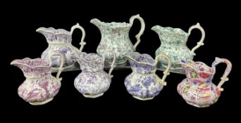 SEVEN WELSH POTTERY JUGS WITH PURPLE / GREEN TRANSFERS comprising three Swansea ‘Oriental Basket’