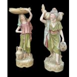 PAIR OF ROYAL DUX WATER CARRIERS, modelled as a male and female standing on naturalistic cylindrical