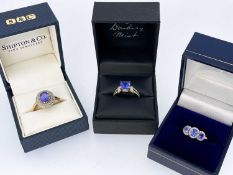 THREE 9CT TANZANITE RINGS, comprising 3-stone, single oval stone and cushion cut square stone rings,