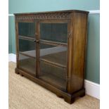 MODERN REPRODUCTION OAK BOOKCASE, with carved frieze, glazed doors, on bracket feet, 120 w x 27 d