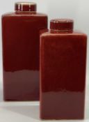 DECORATIVE GRADUATED ROUGE CERAMIC LIDDED VASES (2) - of plain rectangular form, 36cms and 31cms H