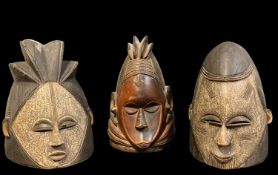 THREE MENDE HELMET MASKS, 27cm h (3)