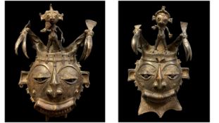 TWO CAMEROON METAL ALLOY MASKS, with bird and figural crests, 54cm H (2)