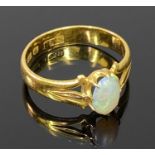 VICTORIAN 22CT GOLD OPAL RING - 7 x 5mm cabochon opal in an open back claw mount against openwork