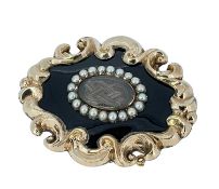 VICTORIAN YELLOW METAL & ENAMEL MOURNING BROOCH, c. 1850, rococo outer frame with oval glass