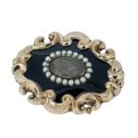VICTORIAN YELLOW METAL & ENAMEL MOURNING BROOCH, c. 1850, rococo outer frame with oval glass