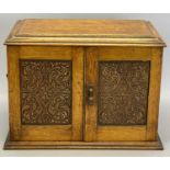 EDWARDIAN OAK SMOKER'S CABINET - the two carved doors and lift-up lid opening to reveal interior