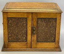 EDWARDIAN OAK SMOKER'S CABINET - the two carved doors and lift-up lid opening to reveal interior