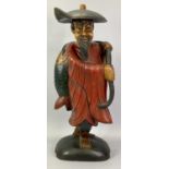 PAINTED WOODEN FIGURE - an oriental man carrying a large fish, 53cms H