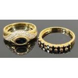 18CT GOLD DRESS RINGS (2) - the first having an inline setting of eight claw mounted black stones,