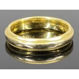 18CT GOLD RAISED CENTRAL BAND RING - having beaded decoration to the inner borders, Size slightly