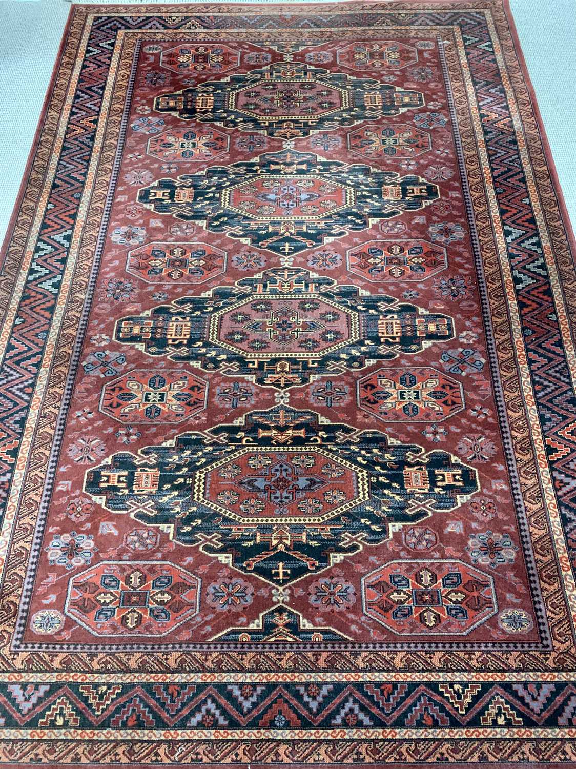 EASTERN WOOLLEN RUG - red ground with multiple zig zag pattern border and four central diamonds
