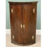 ANTIQUE OAK BOW FRONTED WALL HANGING CORNER CUPBOARD - having twin doors with four interior shelves,