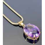 9CT GOLD MOUNTED LARGE FACET CUT AMETHYST PENDANT on a 9ct gold snake link necklace, 33 x 25mm