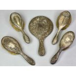 SILVER DRESSING TABLE HAND MIRROR & BRUSHES GROUP - 5 items, all having embossed floral scrolls or