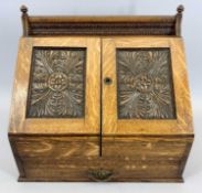 AN OAK STATIONERY BOX - late 19th century, the two floral carved doors opening to reveal interior