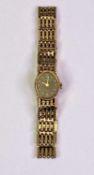 LADY'S 9CT GOLD INTEGRAL BRACELET WRISTWATCH - having an oval black dial, dot markers and Roman