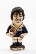 GROGG CARICATURE BY JOHN HUGHES OF ANDY IRVINE standing on titled base, 'Scotland Triple Crown