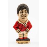 GROGG CARICATURE BY JOHN HUGHES OF AND AUTOGRAPHED BY BARRY JOHN standing on titled base, 'Grandslam