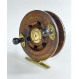 VINTAGE BRASS AND WOOD SEA FISHING REEL, with twin turned handles, brass foot, 14cm diam.