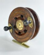 VINTAGE BRASS AND WOOD SEA FISHING REEL, with twin turned handles, brass foot, 14cm diam.