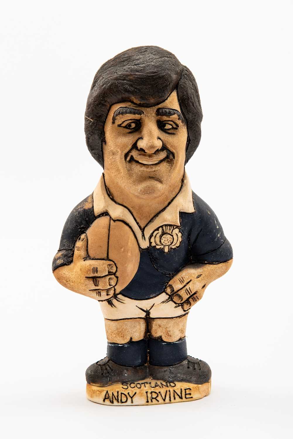GROGG CARICATURE BY JOHN HUGHES OF ANDY IRVINE standing on titled base, wearing his Scotland No.15
