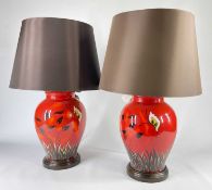PAIR POOLE POTTERY TABLE LAMPS, painted with butterfly and flowers above grasses on a red