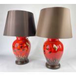 PAIR POOLE POTTERY TABLE LAMPS, painted with butterfly and flowers above grasses on a red