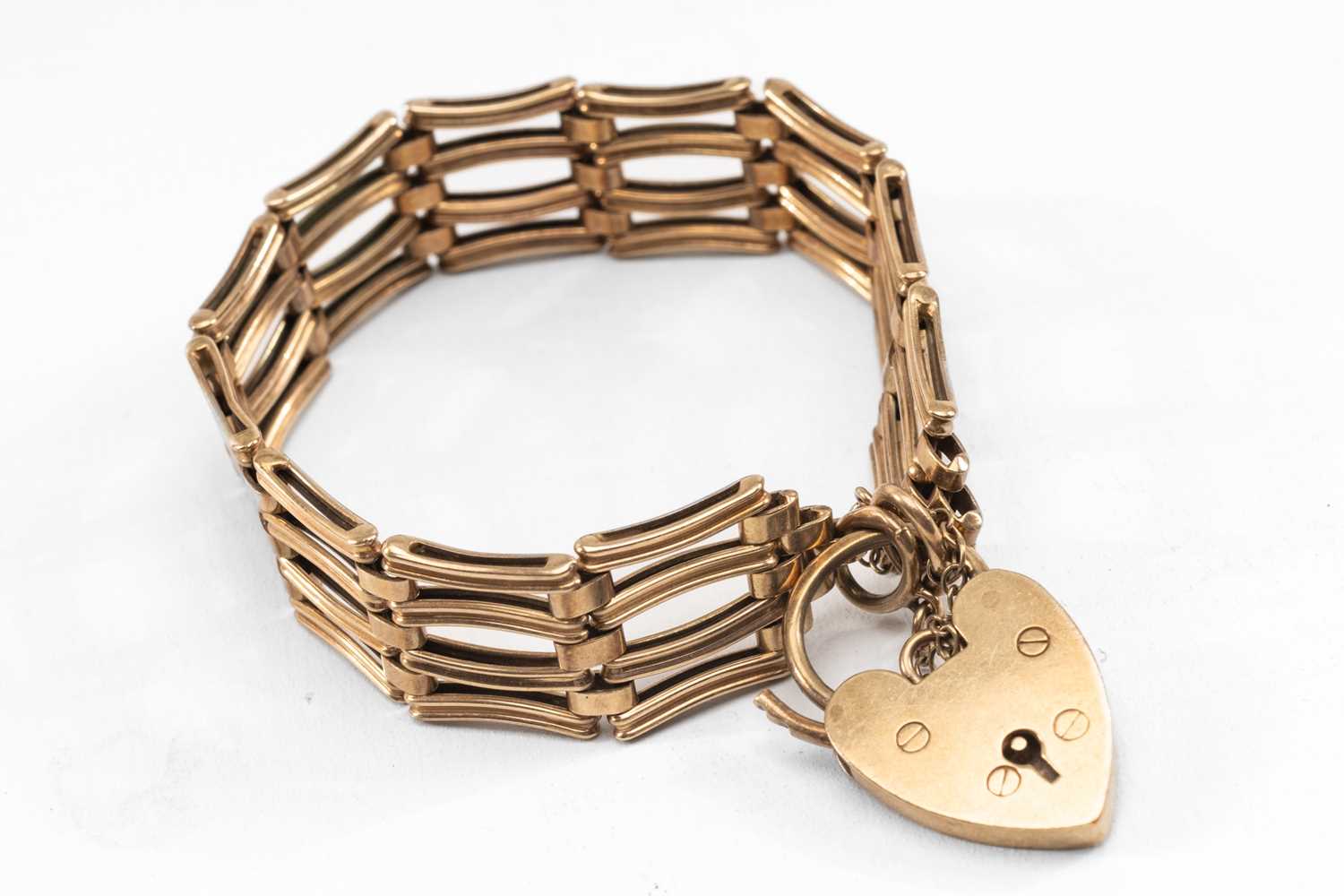 9CT GOLD GATELINK BRACELET, with grooved and bowed links, padlock clasp, wt. 20.6g approx.