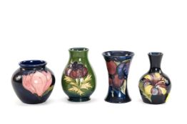 FOUR VARIOUS MOORCROFT POTTERY VASES, including 'Wisteria' pattern trumpet vase, 'Hibiscus'