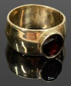 9CT GOLD BROAD BAND RING - set with an oval cut garnet, Size O, 7.9grms