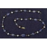 18CT GOLD TANZANITE & GREY PEARL NECKLACE BY DOWER & HALL stamped '750' to the lobster clasp, having