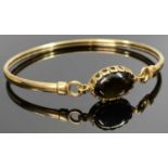 9CT GOLD BANGLE - having an oval cabochon black stone, 5.7grms