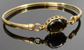 9CT GOLD BANGLE - having an oval cabochon black stone, 5.7grms