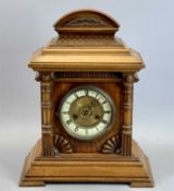 GERMAN WALNUT CASED MANTEL CLOCK - the arched top with carved fish scale decoration, circular dial