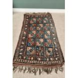 G H FRITH ORIENTAL RECTANGULAR WOOL RUG - blue and rust, having fifteen rectangular central panels