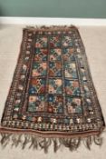 G H FRITH ORIENTAL RECTANGULAR WOOL RUG - blue and rust, having fifteen rectangular central panels