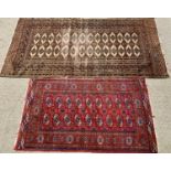 TWO EASTERN STYLE WOOLLEN RUGS - both red ground with wide bordered edging and central repeating