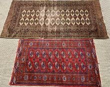 TWO EASTERN STYLE WOOLLEN RUGS - both red ground with wide bordered edging and central repeating