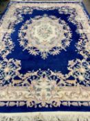 LARGE CHINESE WASHED WOOLEN CARPET with tasselled ends, blue and cream ground, with wide floral