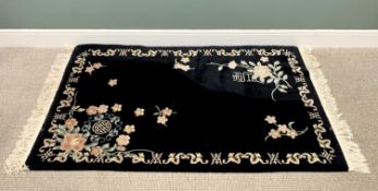 CHINESE WASHED WOOLEN RUG in black, with tasselled ends, having an open border with traditional
