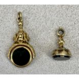 19TH CENTURY UNMARKED GOLD COLOUR WATCH FOB SEALS (2) - the larger with swivel double sided seal