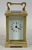 SMALL GILT BRASS CASED CARRIAGE CLOCK - with four glass panels, white enamel dial with black Roman