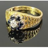 18CT GOLD DIAMOND & BLUE SAPPHIRE RING - illusion set central diamond surrounded by six claw set