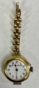 LADY'S VINTAGE 15CT GOLD CASED WRISTWATCH - on rolled gold bracelet, the white dial marked 'Thomas