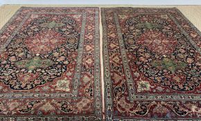 PAIR ISFAHAN RUGS, each with red floral medallion between green oval panels, on a dark scrolling