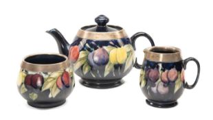 MOORCROFT SILVER MOUNTED 'WISTERIA' PATTERN TEASET, solid dark blue ground, comprising milk jug,