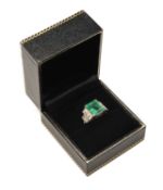 WHITE METAL DIAMOND & EMERALD RING, the central step cut emerald (10 x 8.5 x 6mms approx.) in corner