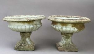 TWO COMPOSITION GARDEN URNS with gadrooned bowls on square based plinths (2)