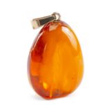 LARGE AMBER PENDANT, of pebble form with flute-polished sides, yellow metal suspension loop (